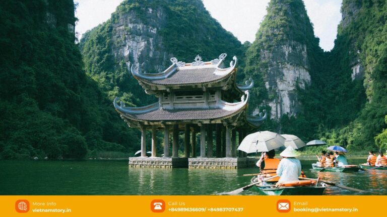 Boat travelling through the limestone landscape at Trang An in Ninh Binh